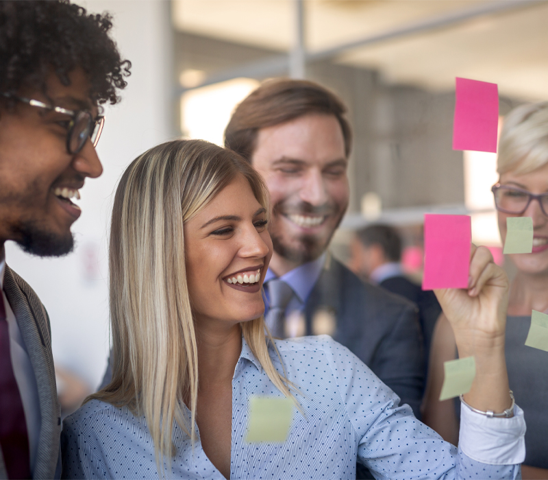Notizenwand Mitarbeiter Kollegen fröhlich